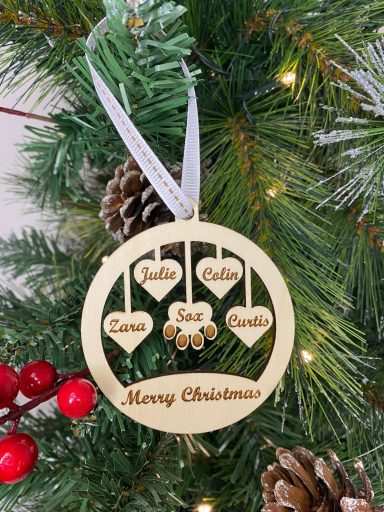 A wooden Christmas ornament with heart shapes and the text "Merry Christmas."